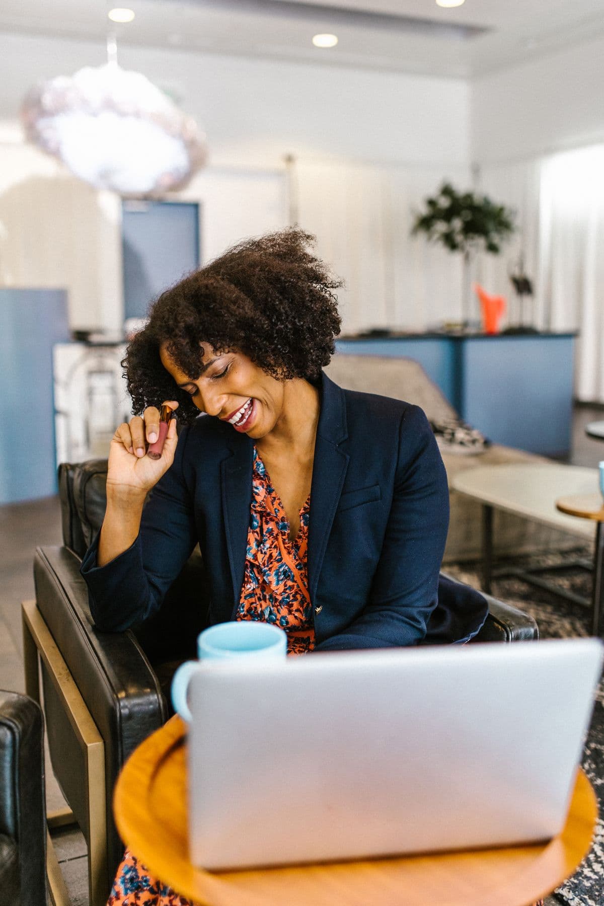 A Black woman working at her laptop in an office.